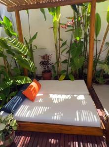 a bench on a porch with plants at Pousada Praiana in Porto De Galinhas