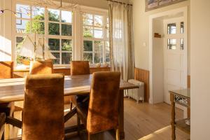 a dining room with a wooden table and chairs at B&B Dreamcottage in Knokke-Heist +14 photos