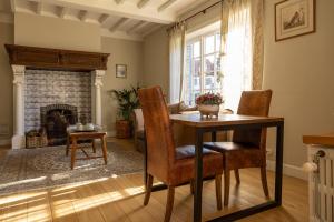 a dining room with a table and chairs and a fireplace at B&B Dreamcottage in Knokke-Heist