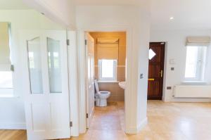 a white bathroom with a toilet and a sink at 5 The Cloisters - Waterville in Waterville +15 photos