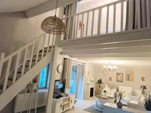 a living room with a staircase and a tv at Pierres & prée Cocon de Charme et sa terrasse étoilée in Mettet