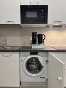 a kitchen with a microwave and a washing machine at Piccola Chappy in Taranto