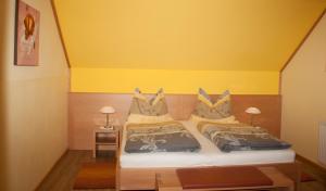 ein Schlafzimmer mit 2 Betten und einer gelben Wand in der Unterkunft Frühstückspension Kuzmic in Wartberg