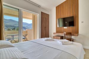 ein Schlafzimmer mit Bett, Fernseher und Tisch in der Unterkunft Gama residence in Becici