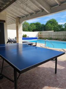 a blue ping pong table in front of a pool at Les Chenets in Chenay