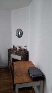 a wooden table in a room with a fireplace at Appartement T2 Rennes Saint Hélier in Rennes +2 photos
