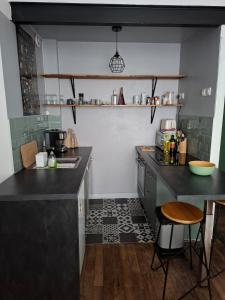 a kitchen with black counter tops and a table at Appartement T2 Rennes Saint Hélier in Rennes