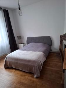 a bedroom with a bed with a gray blanket at Appartement T2 Rennes Saint Hélier in Rennes