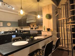 a kitchen with two tables and a counter with chairs at Pierres & prée Cocon de Charme et sa terrasse étoilée in Mettet +43 photos