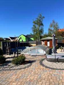 a patio with an umbrella and benches and an archway at Ferienhäuser Radebeul "Sommerresidenz" in Radebeul +3 photos