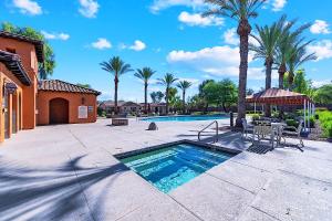 a pool with a table and chairs and palm trees at Getaway at Power Ranch in Gilbert