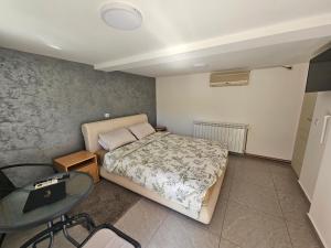 a small bedroom with a bed and a table at Apartman Centar in Srbobran