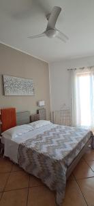 a bedroom with a large bed and a ceiling fan at La Casa di Birba in Acquedolci