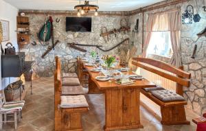 a dining room with a wooden table and a stone wall at Gorgeous Home In Buzim in Bužim +21 photos