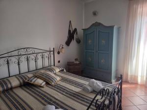 a bedroom with a bed and a blue cabinet at Olympus in Paola