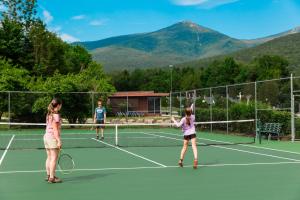 two girls playing tennis on a tennis court at Indian Head Resort in Lincoln