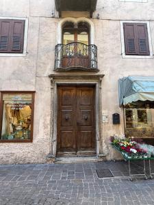 a building with a wooden door and a balcony at Casa singola zona pedonale Fiera di Primiero in Fiera di Primiero
