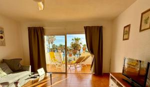 a living room with a couch and a view of a patio at Esmeralda in Callao Salvaje