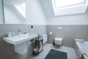 a white bathroom with a sink and a toilet at Fernruh Eifel in Dahlem +25 photos