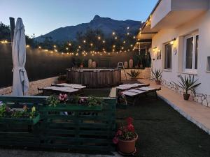 a patio with tables and a umbrella and lights at la mengola holiday and relax in Trivio