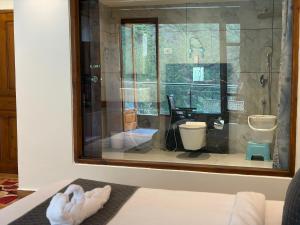 a room with a window with a toilet in it at Hotel Asiia Holiday with Swimming Pool -Central Heated and Air Cooled, Near mall road in Kasol