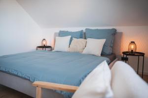 a bedroom with a blue bed with pillows and two lamps at Fernruh Eifel in Dahlem