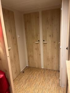 two doors in a room with wood paneling at La roulotte des écuries in Saint-Pierre-de-Chemillé