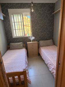 a bedroom with two beds and a window at Apartamento nora in Ceuta
