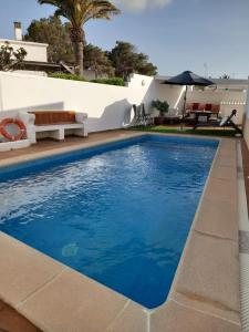 a swimming pool with blue water in front of a house at LEIDA - Relax y privacidad in Cala Blanca