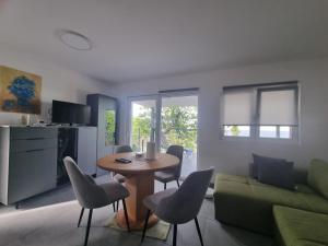a living room with a table and chairs and a couch at Apartmani 'Cvit' in Karlobag