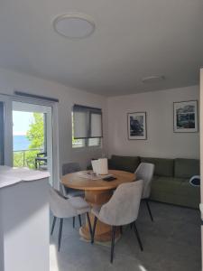 a living room with a table and chairs and a couch at Apartmani 'Cvit' in Karlobag +22 photos