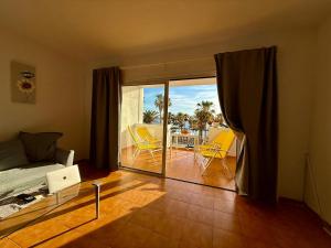 a bedroom with a bed and a balcony with yellow chairs at Esmeralda in Callao Salvaje +26 photos