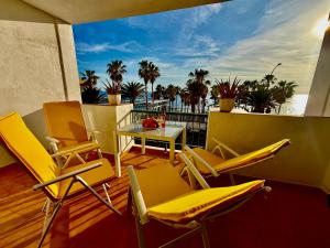 a patio with chairs and a table on a balcony at Esmeralda in Callao Salvaje