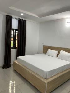 a bedroom with a large bed in front of a window at Lloyd hotel in Benin City