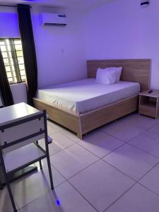 a bedroom with a bed and a table and a chair at Lloyd hotel in Benin City