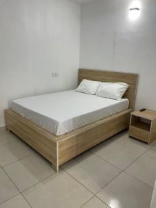 a bed with a wooden frame in a room at Lloyd hotel in Benin City