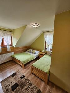 a bedroom with two beds and two windows at Agroturystyka Pod Sosnami w Atenach in Nowinka
