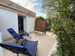 a pair of chairs and a table on a patio at Studio vert à 400 m de la plage in Le Pradet