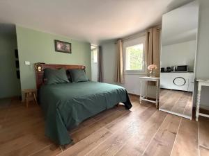 a bedroom with a bed with a green comforter at Studio vert à 400 m de la plage in Le Pradet
