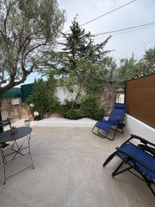 two blue chairs and a table on a patio at Studio vert à 400 m de la plage in Le Pradet +8 photos