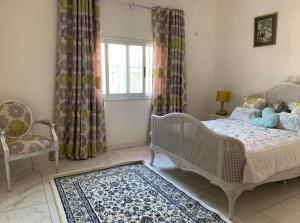 a bedroom with a bed and a chair and a window at Linda's Guest House in Rotouma