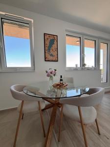 a dining room with a glass table and two chairs at Penthouse-Villa Natura in Hegykő +10 photos