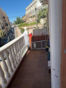 a balcony with a white railing and a street at Apartamento nora in Ceuta +2 photos