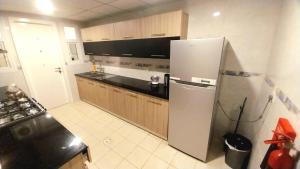 a kitchen with a refrigerator and a counter top at Beach star residency 2 in Muscat