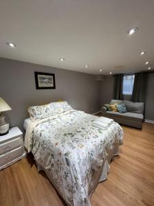 a bedroom with a bed and a couch at 2 Bedroom 1 Bathroom Basement Suite in Toronto
