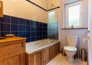 a bathroom with a toilet and a tub and a sink at An Charraig in Killarney +25 photos
