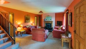 a living room with orange walls and red furniture at An Charraig in Killarney