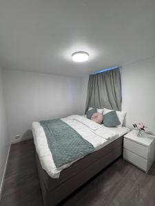 a bedroom with a large bed with a window at Central leilighet i Kristiansand Vågsbygd in Kristiansand