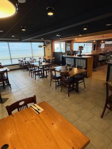 an empty restaurant with wooden tables and chairs at Le Délice Motel Restaurant in Mont-saint-pierre