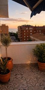 a balcony with potted plants and a view of a city at Luxury art Apartamenty in Pineda de Mar